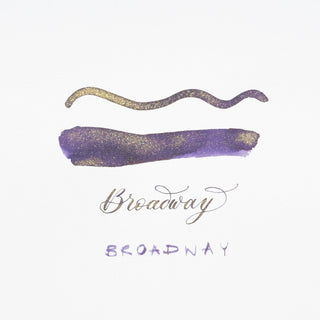 Shimmer Ink - Broadway in purple and gold is swatched above “Broadway” in cursive, with the name also written in uppercase letters below, highlighting this fountain pen ink’s vibrant shimmer on a white background.