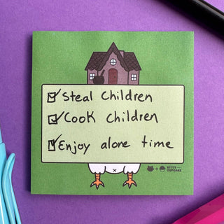 The Baba Yaga Sticky Notes show a cartoon chicken-legged house and a checklist—Steal Children, Cook Children, Enjoy alone time—all marked. This witchy stationery sits on a purple surface with pens beside it.