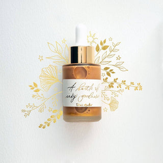 A bottle of Premium Calligraphy Ink with a gold cap and handwritten label is centered on a white background, surrounded by elegant gold floral illustrations—ideal for storing your favorite calligraphy ink.