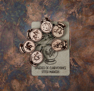 The 🔮 Crystal Ball Stitch Marker Set 🔮 features six cherry wood markers with engraved potion bottles and crystal balls—witchy accessories perfect for adding mystical charm to your knitting projects.