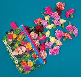 The Frida Zipper Bag displays a Frida Kahlo design on a blue background, with vivid pink, red, and yellow carnations bursting from the open zipper.