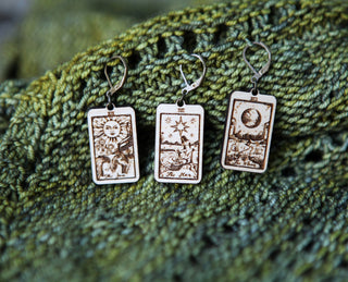 🔮 Tarot Card Stitch Markers – The Moon, The Star & The Sun 🔮 are displayed on textured green fabric, perfect for repurposing as unique progress keepers or knitting accessories.