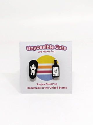 Two enamel pins on a display card: one features a girl with braided hair, the other a poison bottle. The card reads Unpossible Cuts, We Make Fun, Handmade in the USA—pairs perfectly with our Wednesday Stud Earrings.