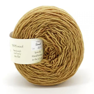 Freia Semi-Solid Sport Wool Yarn in Sand is a light brown, sport-weight yarn made from 100% US wool. It comes with a white label that lists fiber content and care instructions.