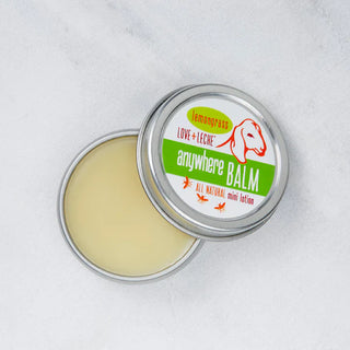 An open round container of Little Bee Anywhere Balm reveals the nourishing beeswax balm inside.