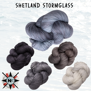 Five skeins of gray, black, and off-white yarn are displayed on a light background. The Knitmas in July Knitting Kit 2026 features the classic Old Shale motif. "Shetland Stormglass" is shown at the top.