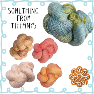 Five pastel skeins from the Twelve Days of Knitmas | 2025 Yarn Kit are displayed, with “Something from Tiffanys” at top left. A cookie decorated “NK” sits bottom right—all inside a blue border. Perfect for kit fans!.