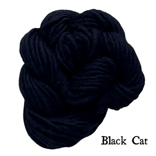 A bundle of Black Cat yarn for a Tatters the Cat Poppet | Knitting Kit, with the text Black Cat printed in the bottom corner.