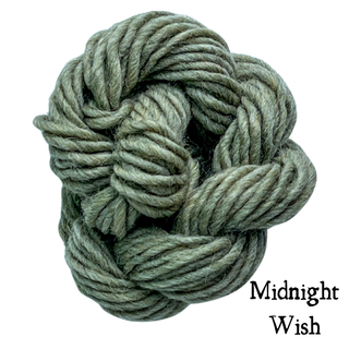 A ball of sage green yarn for the Tatters the Cat Poppet | Knitting Kit twisted into an intention knot, with the text Midnight Wish in the bottom corner.