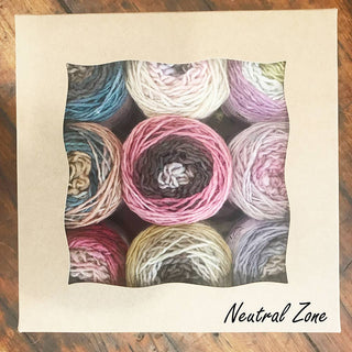A wavy-edged window box displays nine multicolored Freia Minikin Palette Packs fingering merino yarn balls—perfect for Fair Isle sweaters—in pink, blue, yellow, and neutral shades. “Neutral Zone” is written in the bottom right corner.