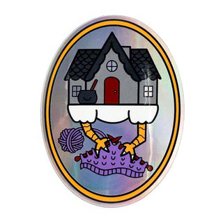 The Baba Yaga Knitting Holographic Sticker features her house on chicken legs, knitting with purple yarn and needles beside a cauldron—set on an iridescent background, perfect for fans of witchy crafts and folklore.