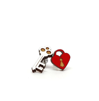 The Key and Heart Lock Earrings are a mismatched hypoallergenic pair—one silver key and one red heart-shaped padlock with a gold keyhole—displayed on a white background.
