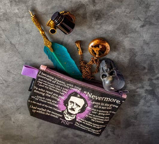 A flat lay of Edgar Allan Poe-themed items: an Edgar Allan Poe Zipper Bag adorned with literary quotes, a gold pocket watch, a raven skull figure, a teal-feather quill pen, and an ink bottle—perfect for Halloween and literature fans.