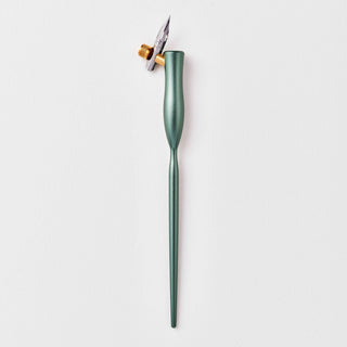The Flourish Calligraphy Pen, a green oblique holder with a metallic nib and brass flange, is ideal for beginners and is shown standing upright on a white background.