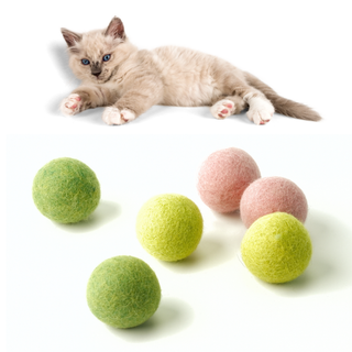 A light-colored kitten with blue eyes rests above six Wool Felted Cat Toy Balls in green and pink colors, set on a white background.