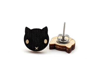 🐈‍⬛ Black Cat Earrings: Hypoallergenic wooden studs shaped like a black cat’s face with light eyes and a small x mouth—perfect Halloween earrings. Shown on a white background.