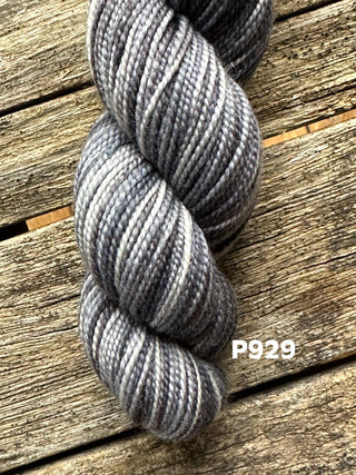 A skein from the KPM and KPPPM Variegated Color Collection rests on a weathered wooden surface. The code P929 appears in white text—ideal for your next hand knitting project.