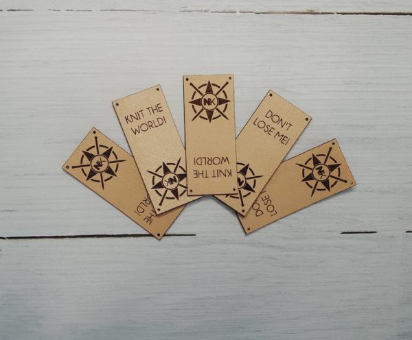 5 light brown vegan leather hat tags with nomadic knits logo and knit the world or don't lose me