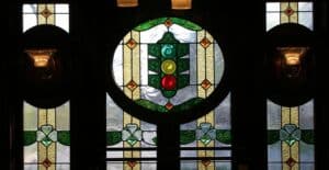A photo of stained glass in Coleman's Irish Pub depicting the upside down traffic light on Tipperary Hill in Syracuse, New York.